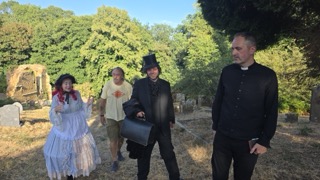 Cast and crew in the graveyard between takes