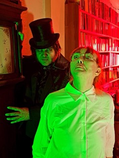 The Ripper behind Eileen Daly in the red and green lit room
