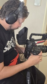 Jason Impey behind the camera wearing headphones