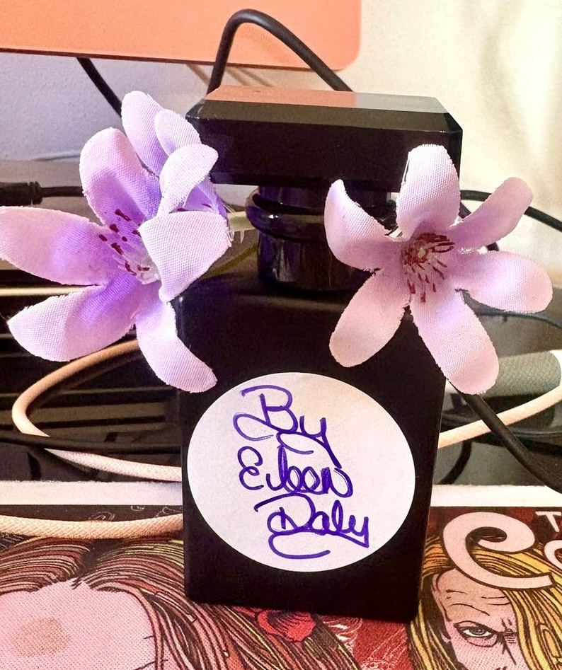 An unlabelled black perfume bottle signed by Eileen Daly, the new Echoes of Crimson scent