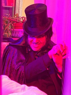 The Ripper lit in pink, leaning in