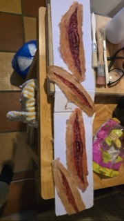 Prosthetic wounds laid out on a board beside brushes and glasses